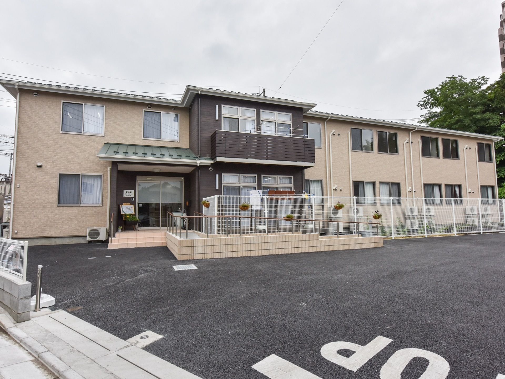 敷地内に駐車場が完備され、屋外はアスファルトで舗装されている。敷地と居住スペースは、白色のフェンスで仕切られている。