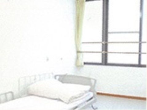 窓に転落防止の手すりが取り付けられている白い壁の居室