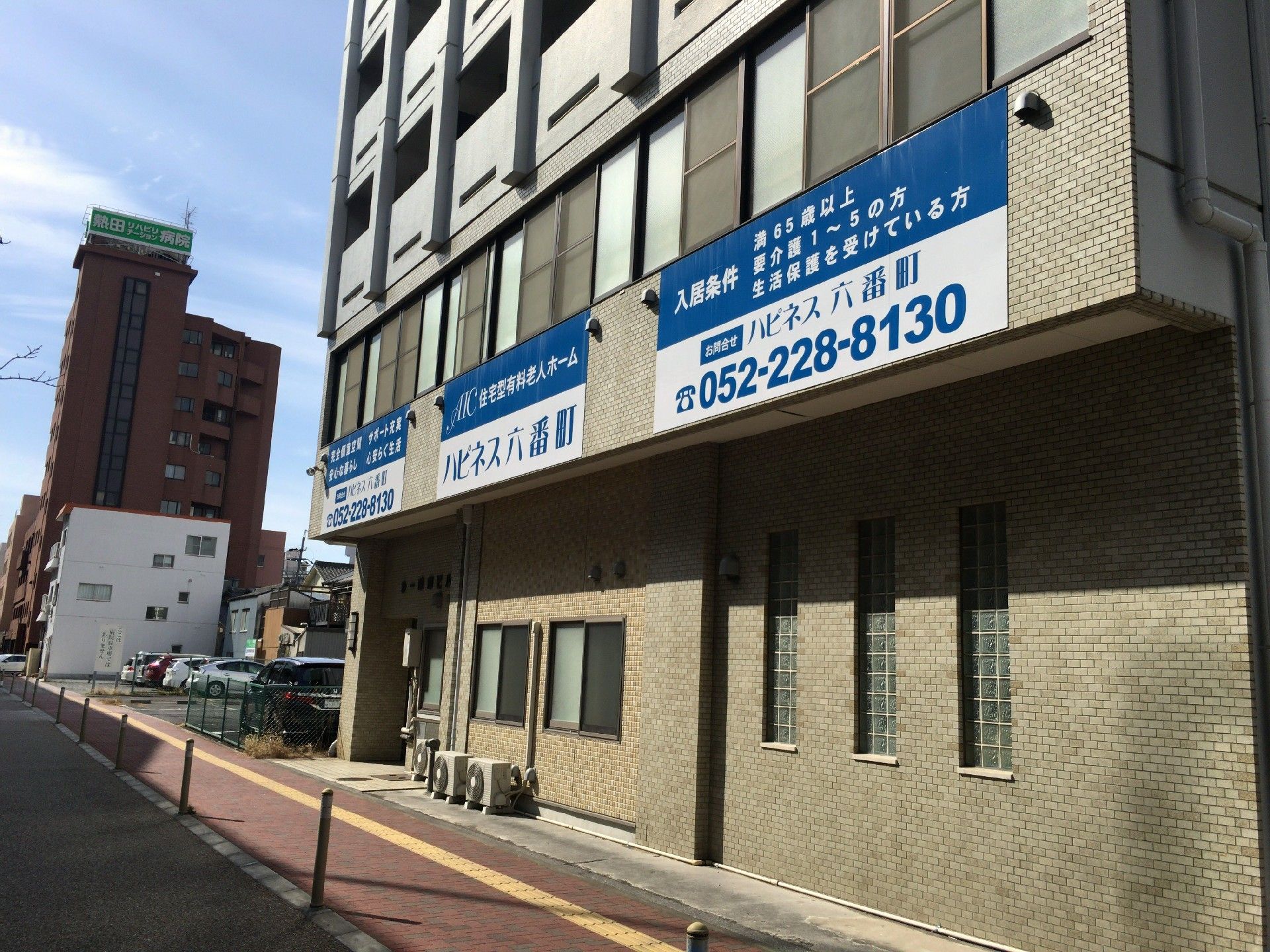 入居受付のプレートが外壁に設置されている施設の外観