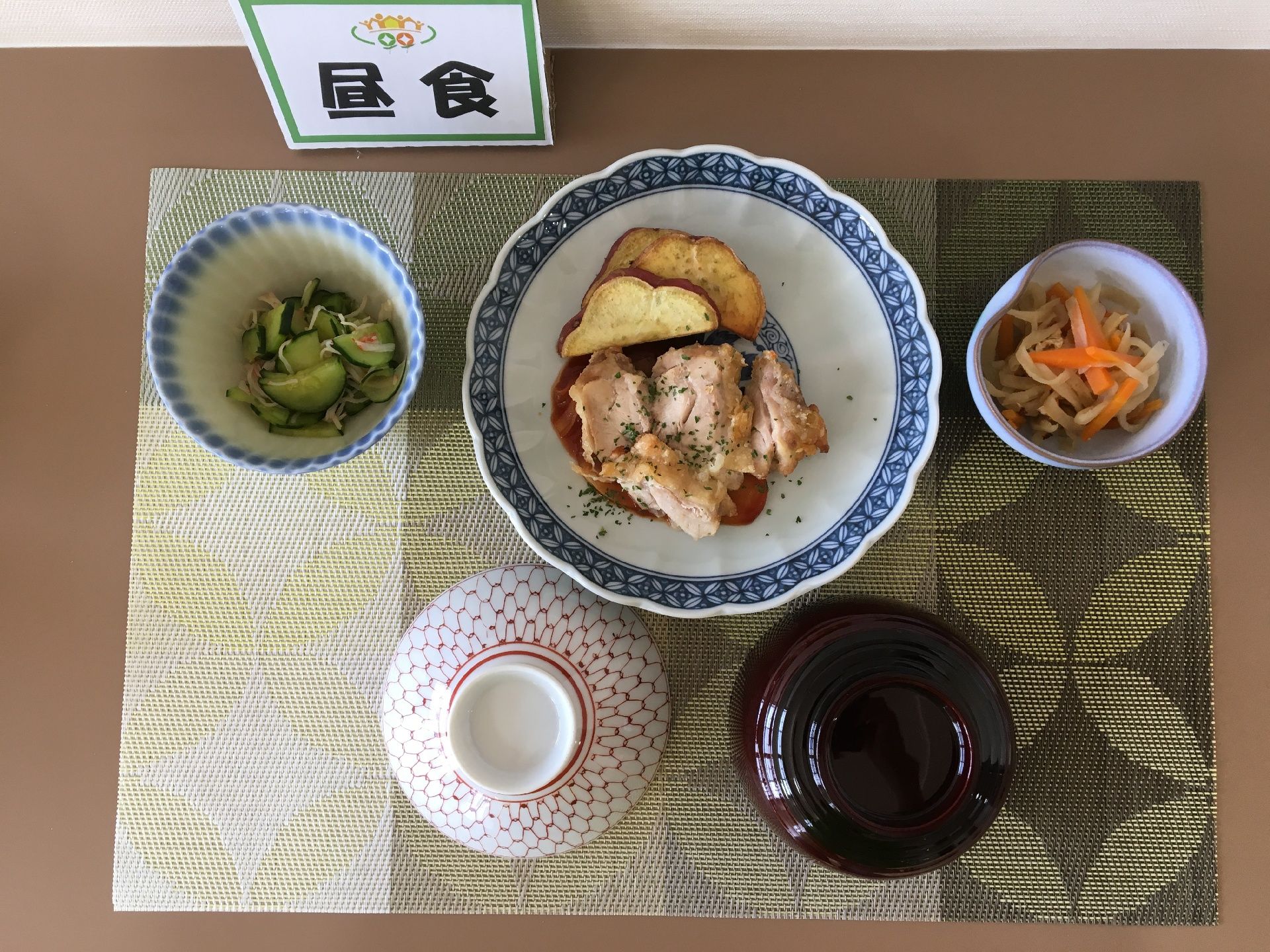 昼食の見本。茶碗と汁椀は伏せてある。主菜が一品、副菜の小鉢が二品用意されている。肉、野菜とバランスのとれた食事内容である。