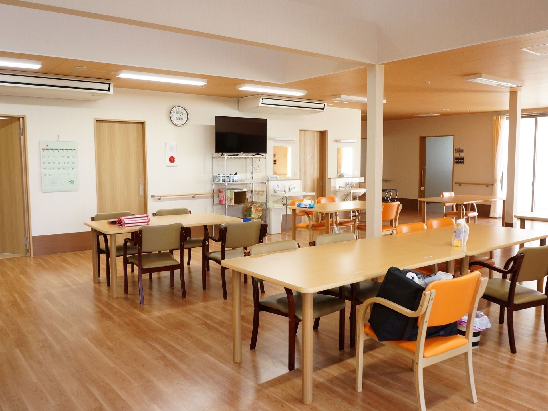 明るい空間の多目的室の奥にはテレビが設置されており、入居者様は食事の際などに自由に視聴することが可能である。