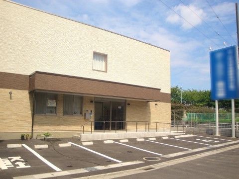 建物はベージュ色の外壁で落ち着いた雰囲気である。玄関までの通路にはスロープが設置されており、車椅子をご利用の方も安心である。