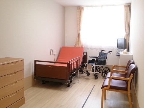 窓から光が差し込む明るい居室である。壁は白く清潔感のあるスペースである。チェストがあり、洋服などを収納できる。