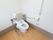 トイレに置かれている便器の両サイドにひじ掛け風の手すりが設置されており、後部には背当てが取りつけられている。
