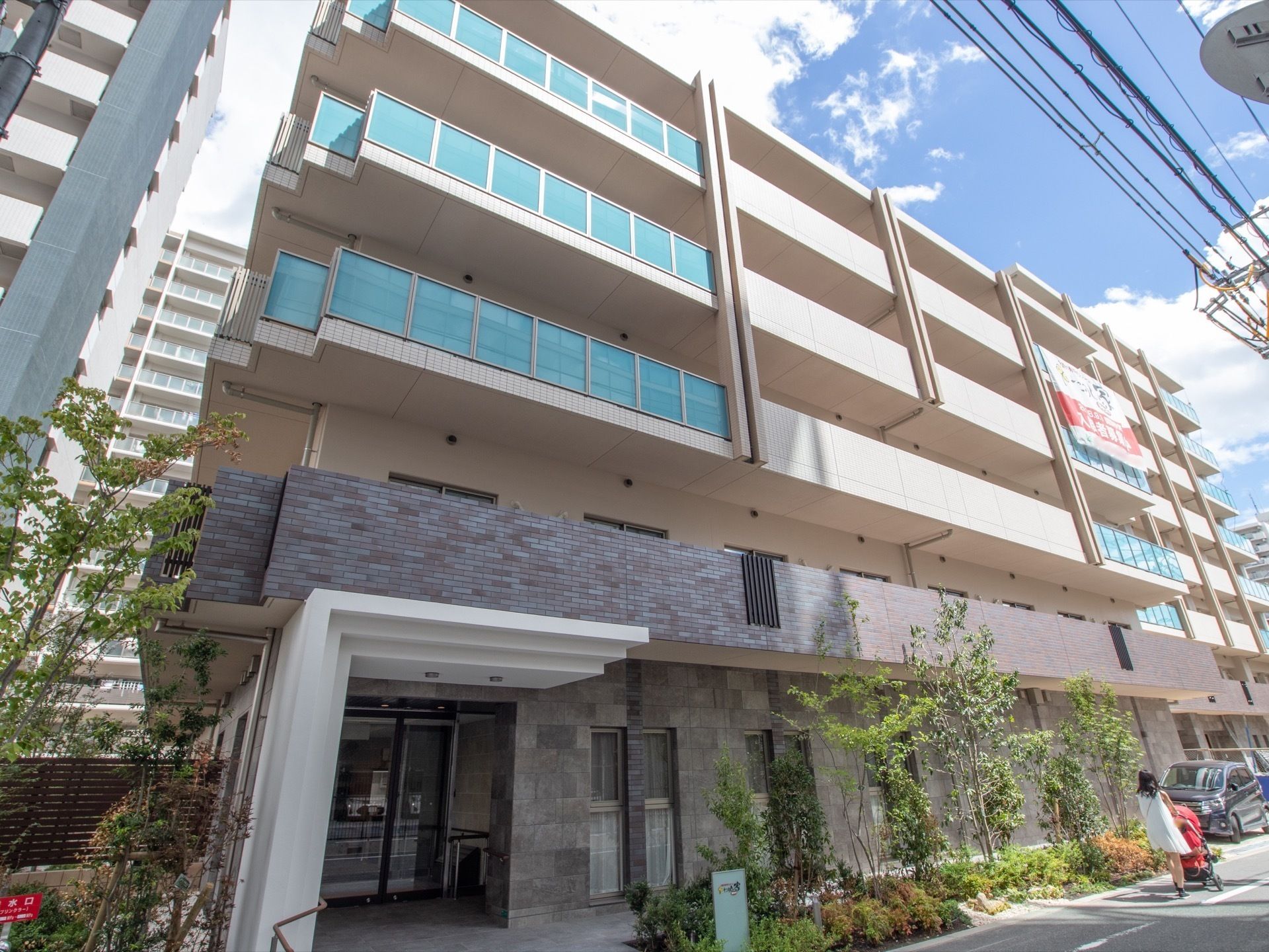 ベランダが完備された５階建て施設を斜め下から見上げた光景