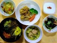 数種類の具材が乗ったどんぶり物や具材のたくさん入った汁物、彩りのいい主菜、食物繊維たっぷりの小鉢にデザートがついた食事が用意されている。