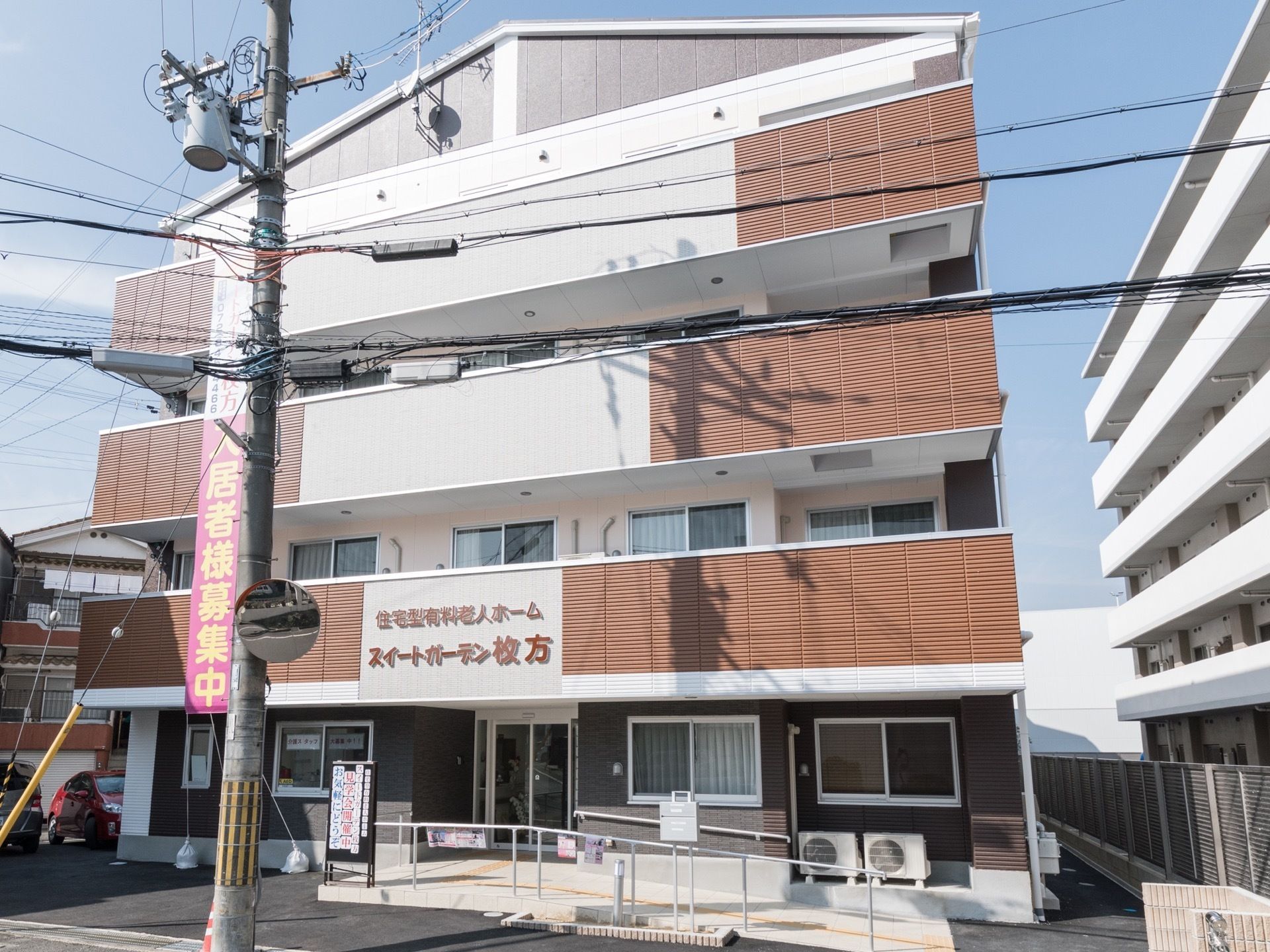 三角屋根の４階建ての建物で、一階の玄関前にはスロープが備わっている。２階より上の各階には、バルコニーがある。