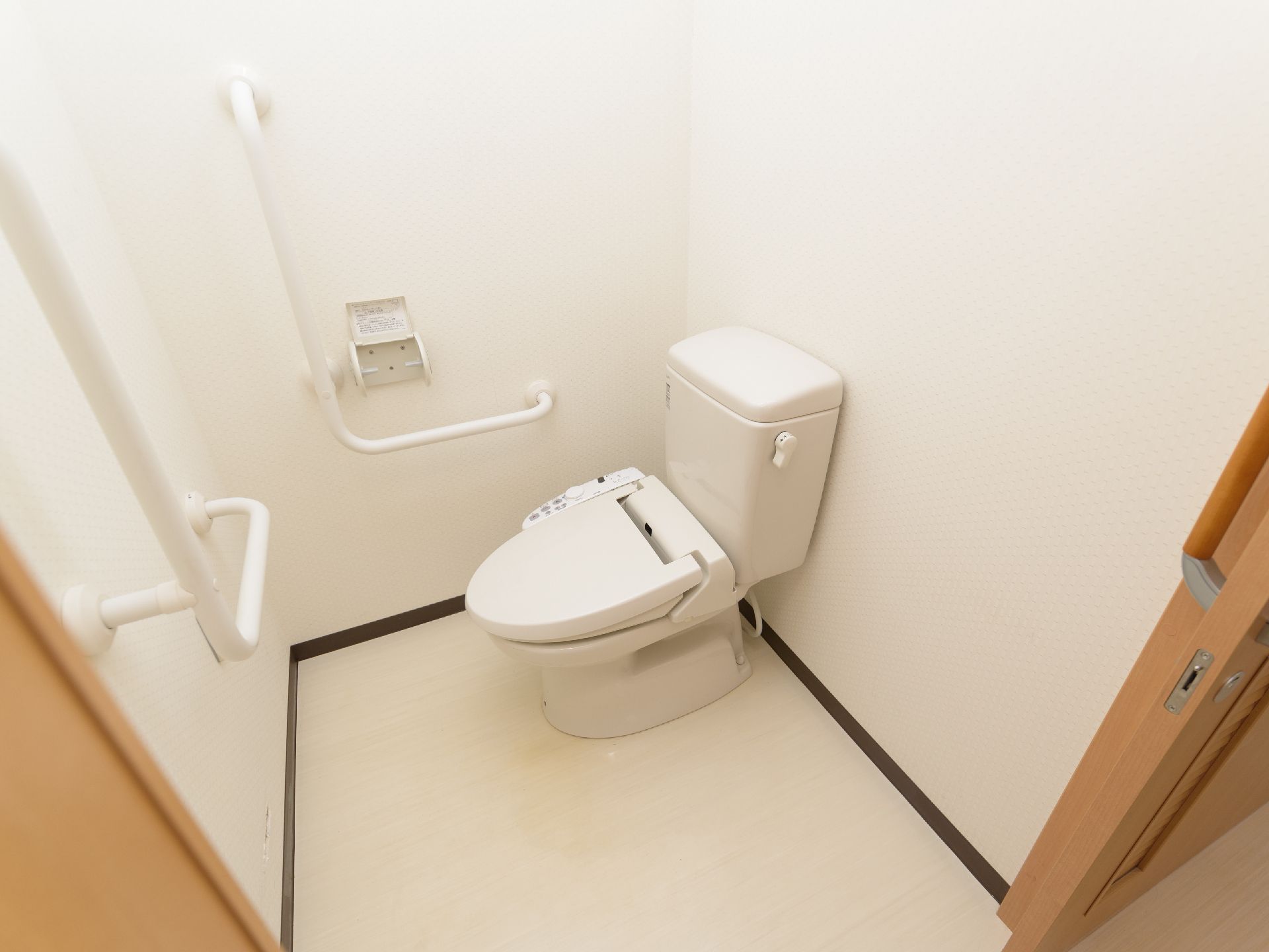 洋式トイレは温水洗浄便座である。和式と比べ、立ち上がりの負担が少なく、手すりも付いているため安心できる。