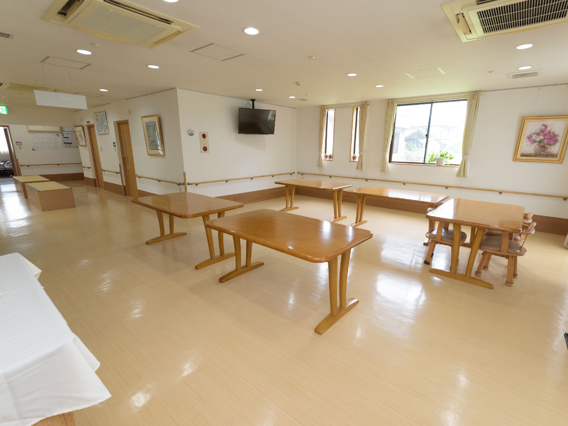 ４人掛けテーブルが複数ある大空間のお部屋。窓がたくさんあるので、日当たりが良く温かみのある空間である。