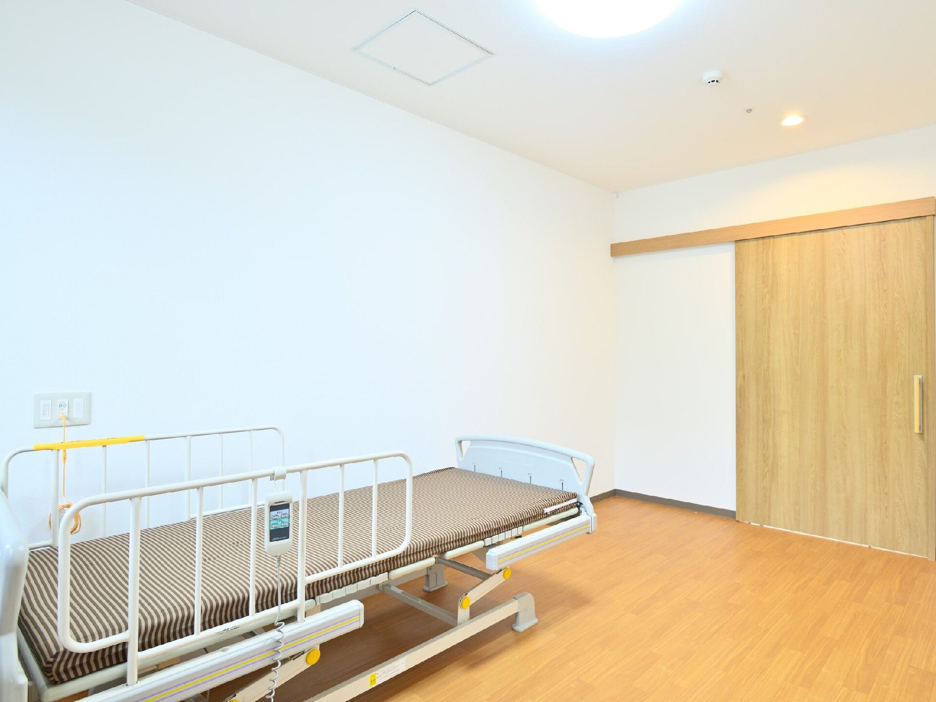 家族と話しながらくつろいでいる高齢者。ベッドの上に座ってリラックスしている