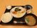 黒いトレーに置かれた１食分の食事である。ご飯と汁物の他にメイン料理とおかず２品、デザートが並んでいる。