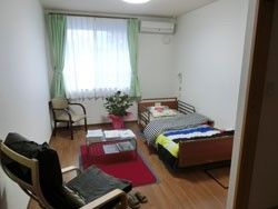 白を基調とした明るい居室には、介護用ベッドやカーテン、椅子、テーブル、エアコンが完備されているので便利である。
