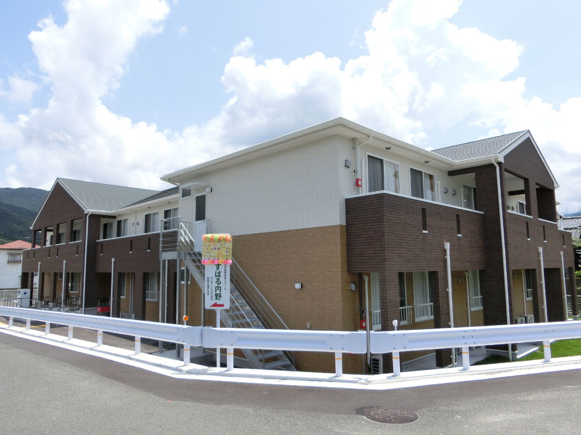 ブラウンとホワイトのバイカラーの外壁で、明るい印象の施設建物