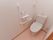 トイレの左側の壁には、Ｌ字の大きな手すりが取り付けられている。その上に、ペーパーホルダーと操作パネルがある。