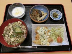 タルタルソースをかけたフライや、サラダ、煮物やデザートが付いたメニュー