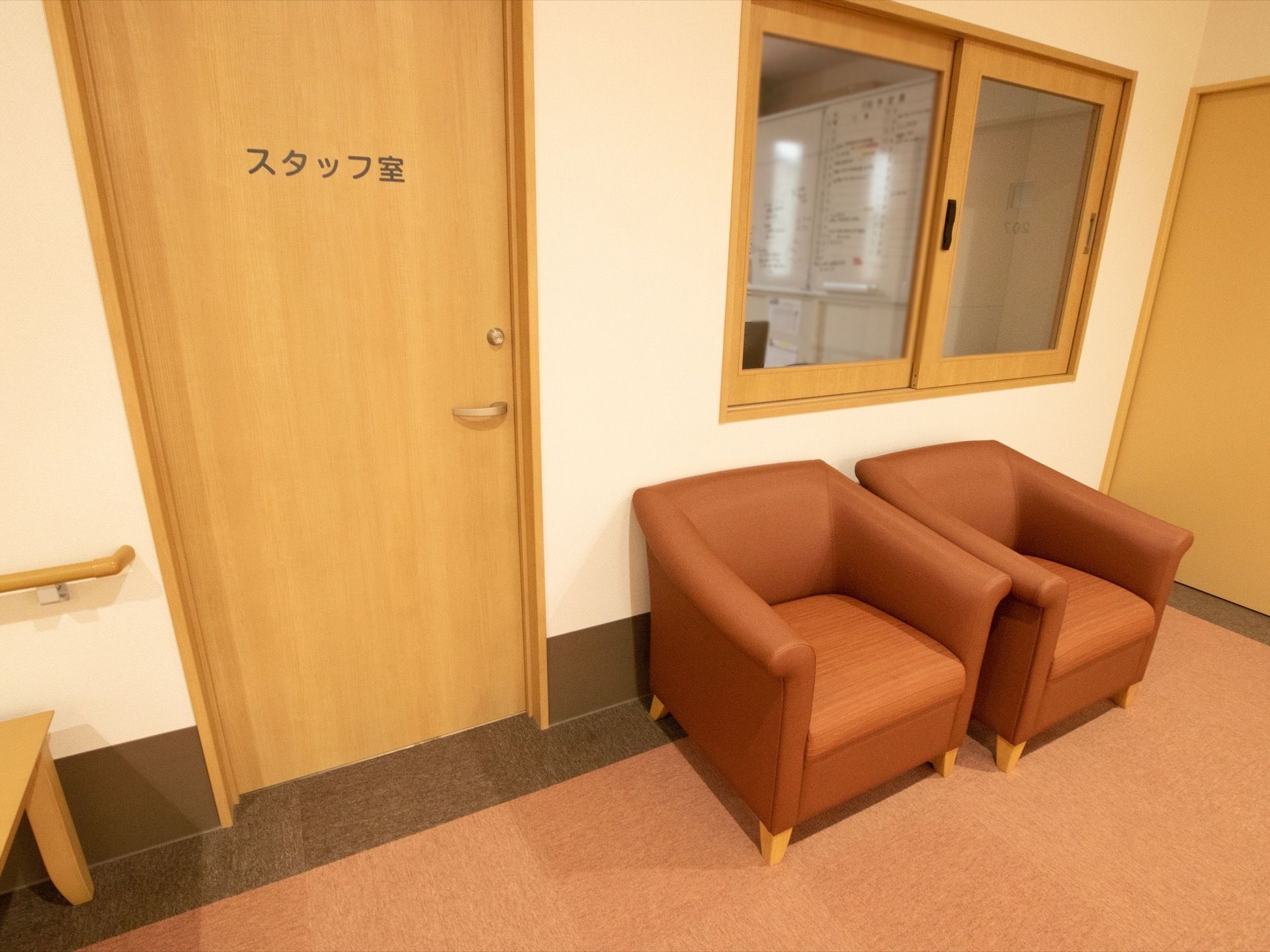 スタッフ室は、２階の浴室の近くにある。ガラス窓があり、室内の様子が見える。ガラス窓のそばに、椅子が２脚置かれている。