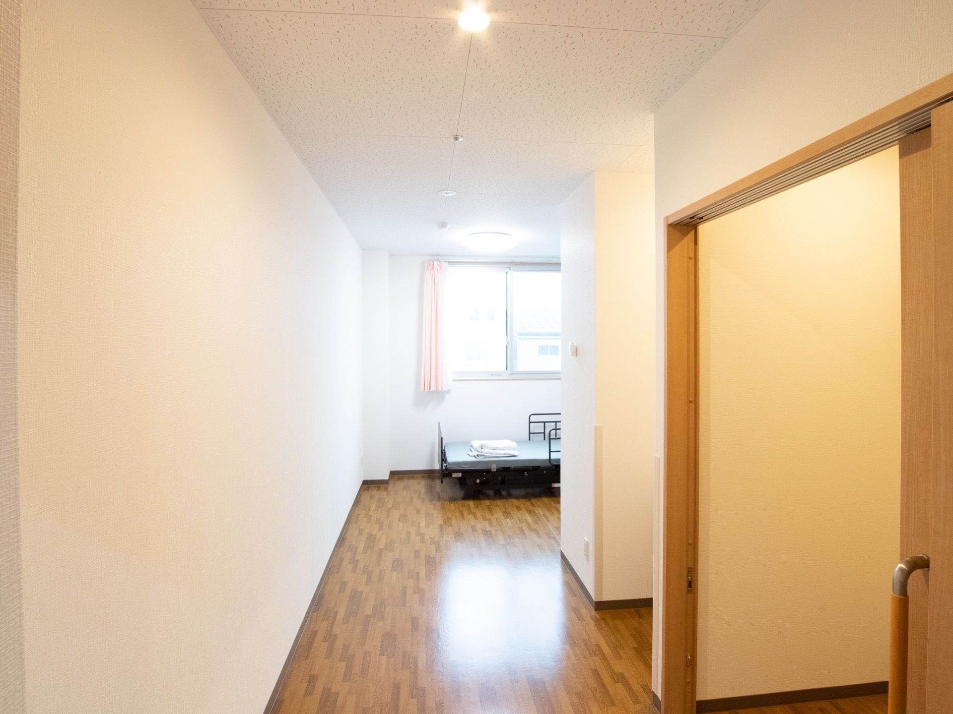 白を基調としたワンルームの個室になっている。床はフローリングである。ベッドが1台置かれている。日当たりが良く、明るい。