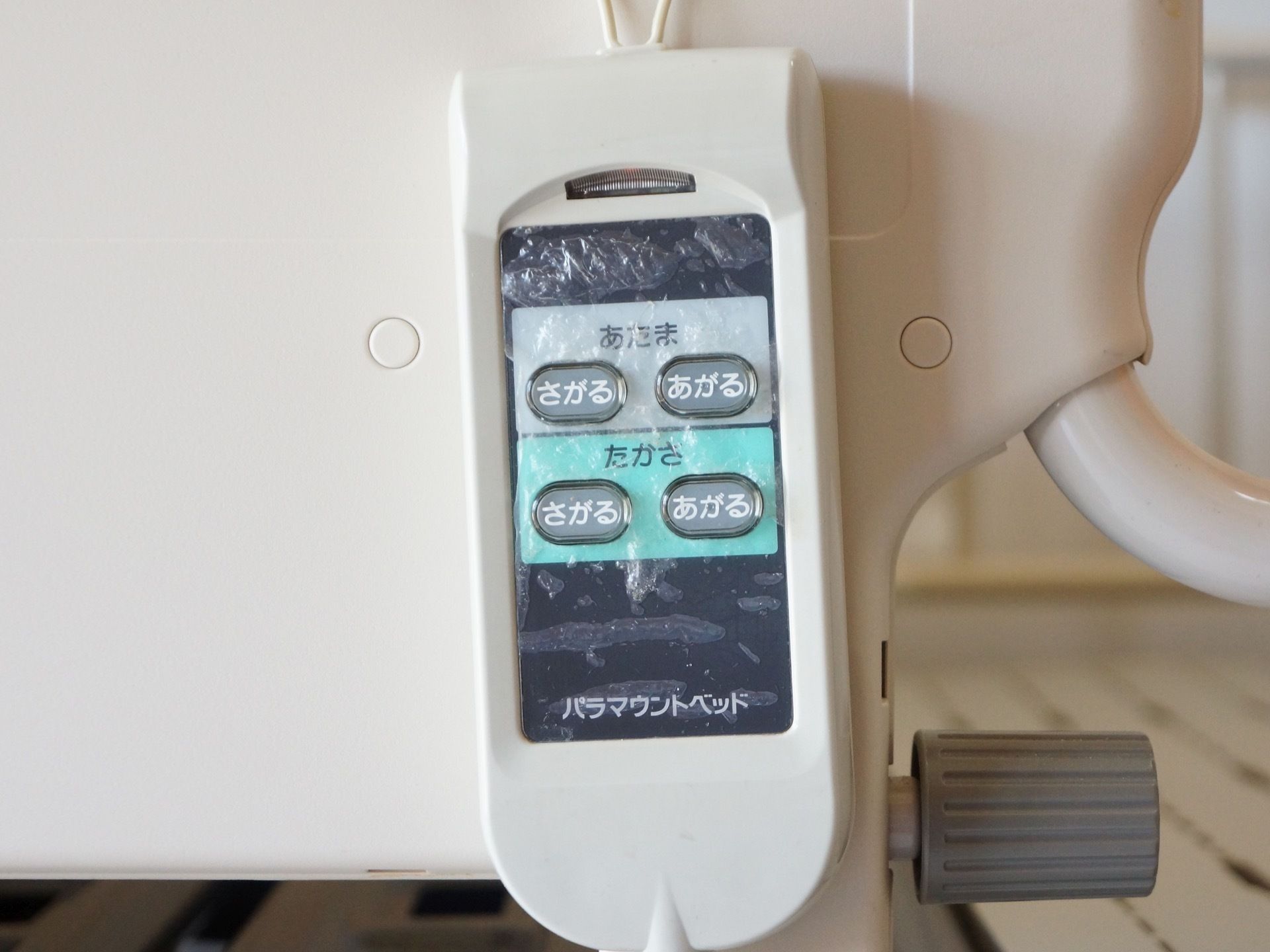 介護ベッドに取り付けられているリモコン。とてもシンプルなデザインで、文字がひらがなで大きく書かれている。