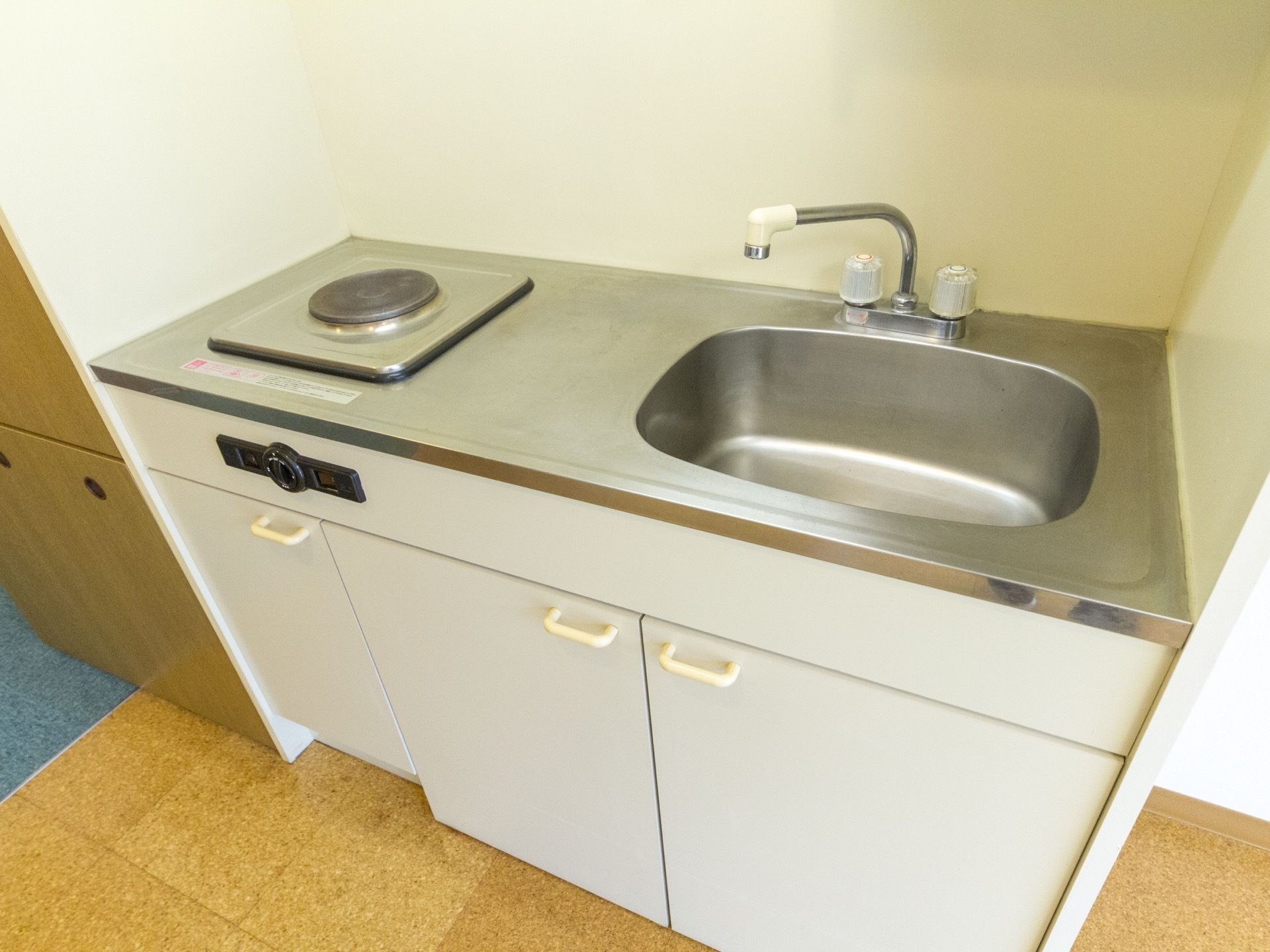 電磁調理器の設置されたキッチンである。下方部は扉付きの収納があり、小さめのキッチンが設置されている。