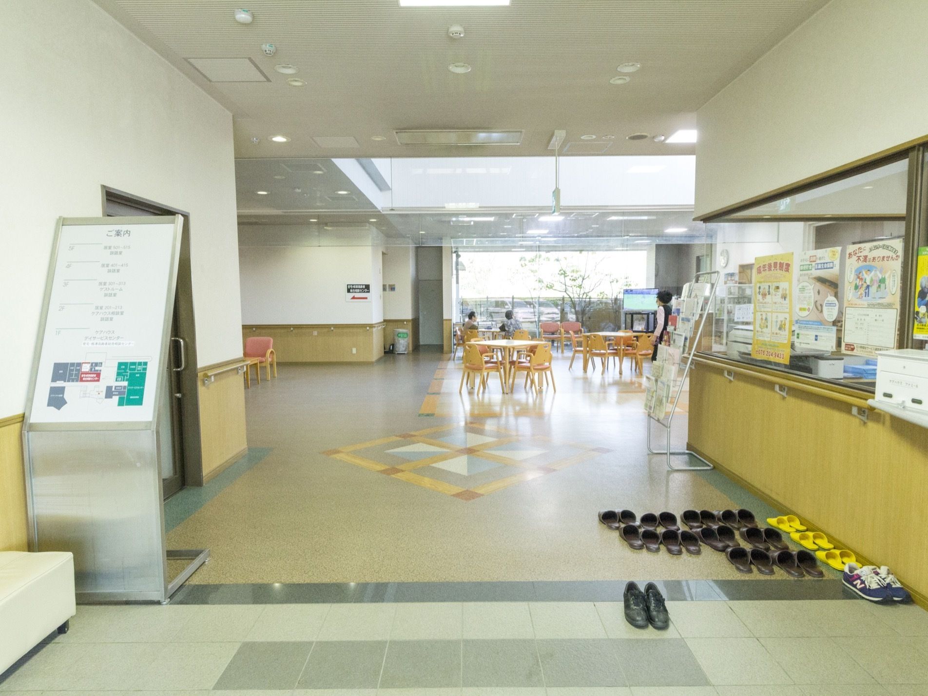 玄関にタイルが貼られていて、バリアフリーである。何足かスリッパが並べられている。銀色の大きな案内板が置かれている。