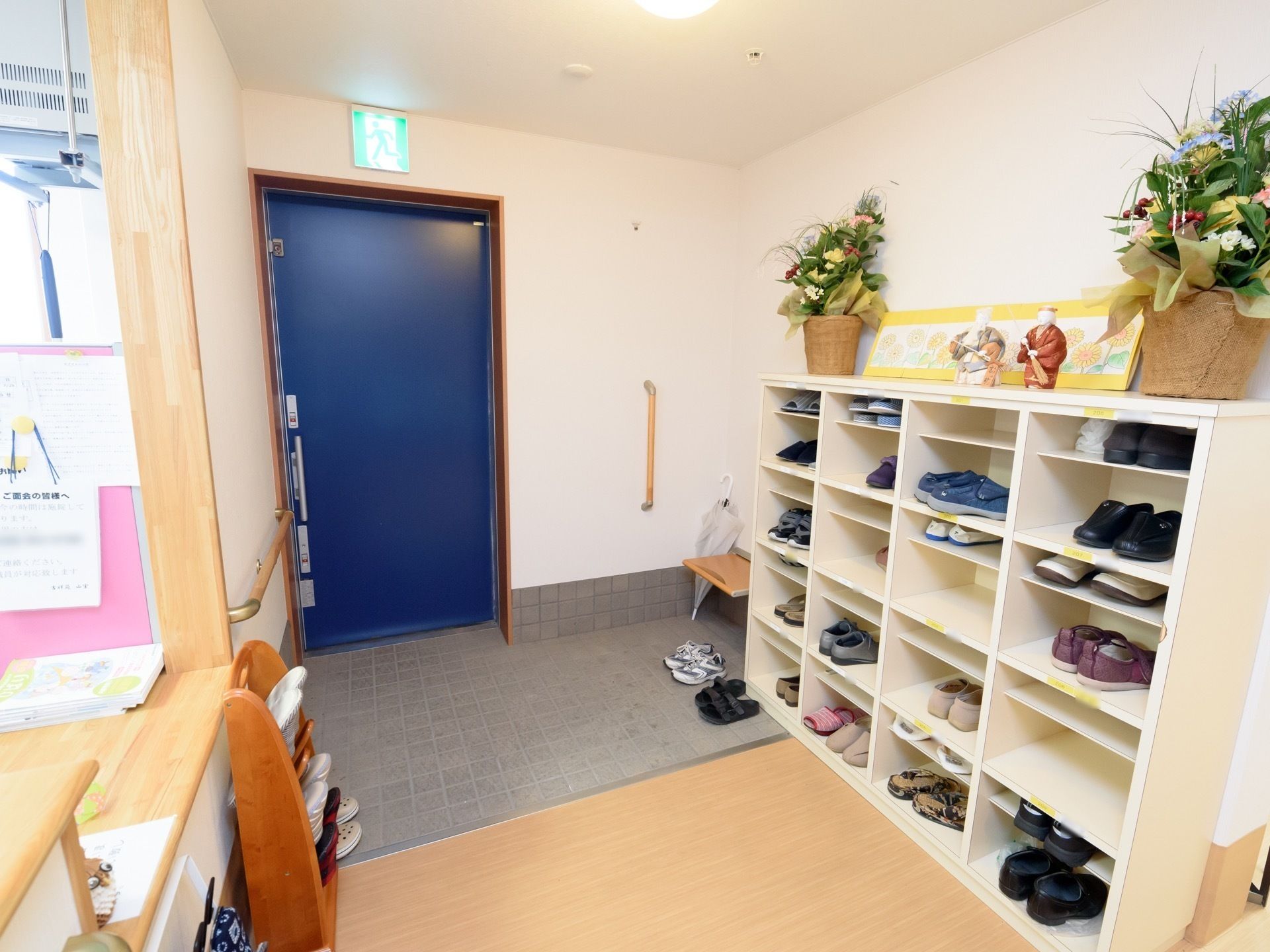 緑の風景を楽しむ入居者様と、車椅子の介助をする笑顔のスタッフ