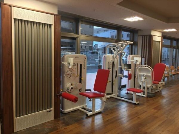 窓際にトレーニング用の器具が置かれた、フローリングの床の部屋