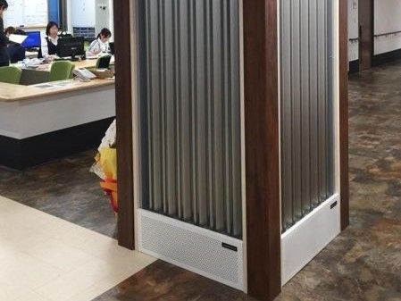 スタッフルームのカウンターに電話が置かれている。空調システムのついた大きな柱が廊下に設置されている。