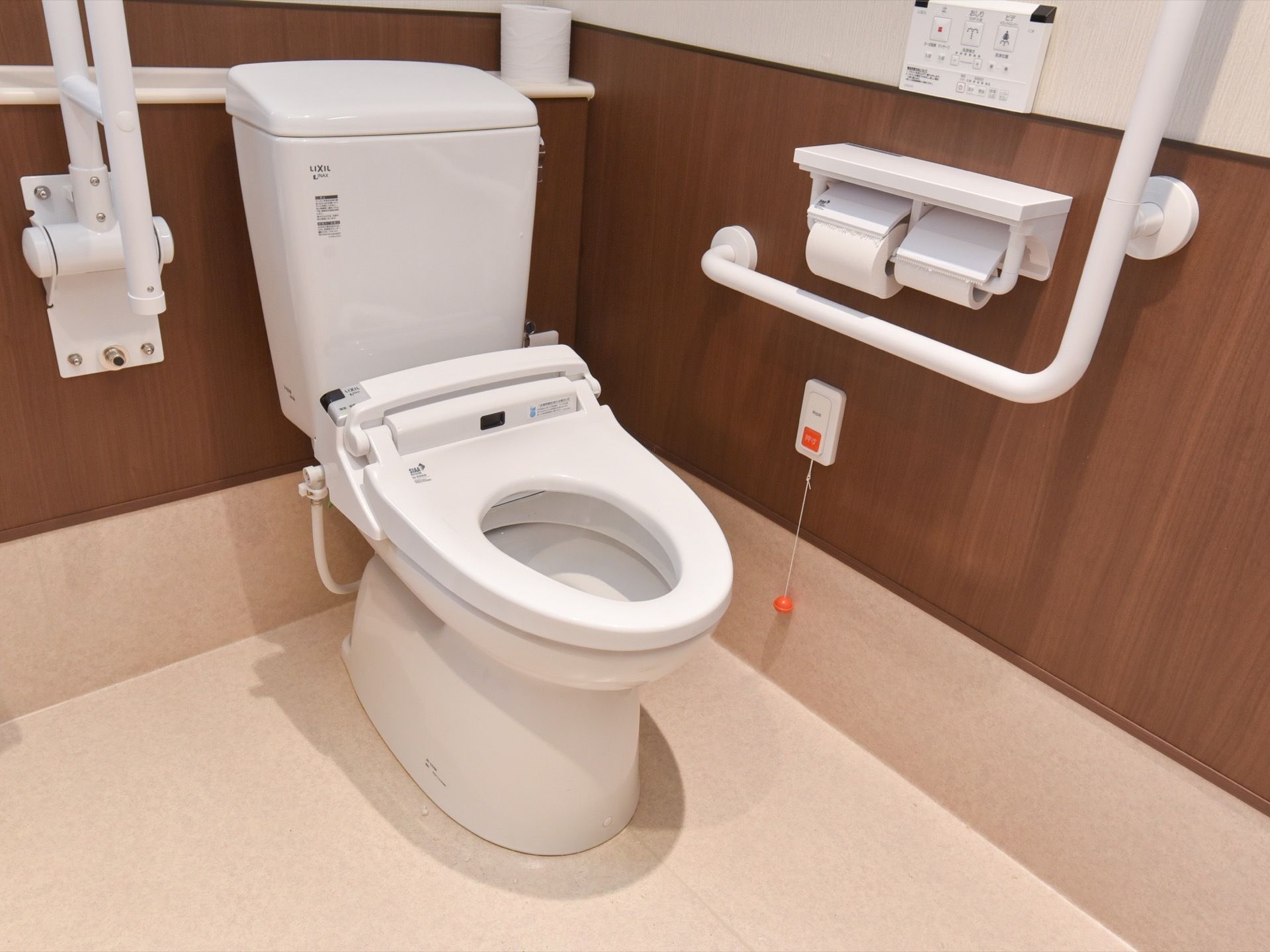 トイレには、Ｌ型や可動式の手すり、呼び出しボタンが壁に設置されている。予備のトイレットペーパーを置ける棚がある。