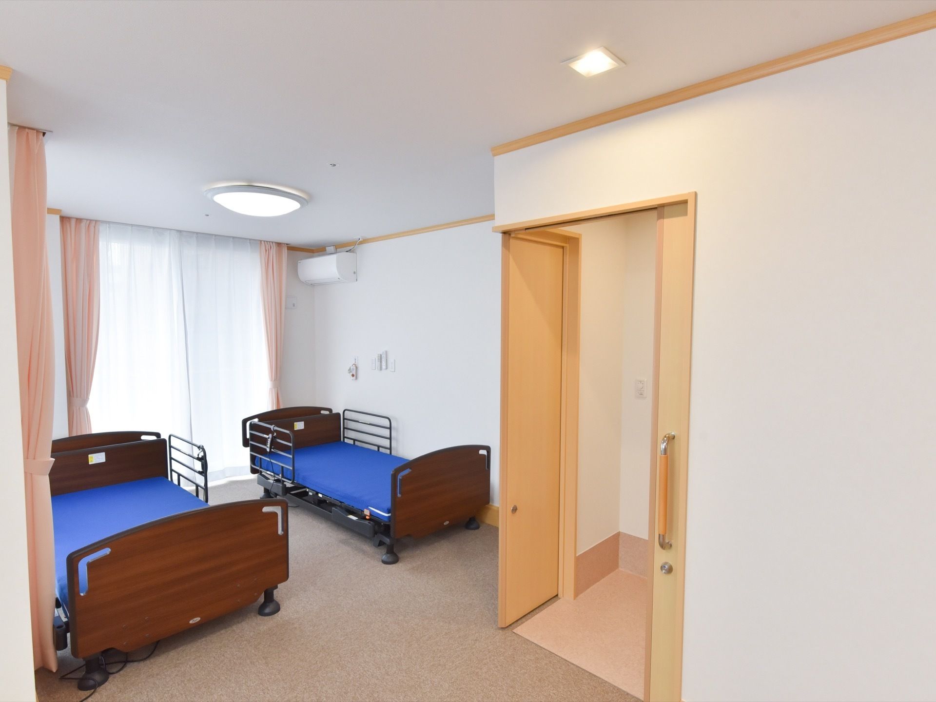 ベッドが二つ入っている二人用の居室。角部屋なので窓が多く設けられ、他の部屋よりも日当たりが良くなっている。