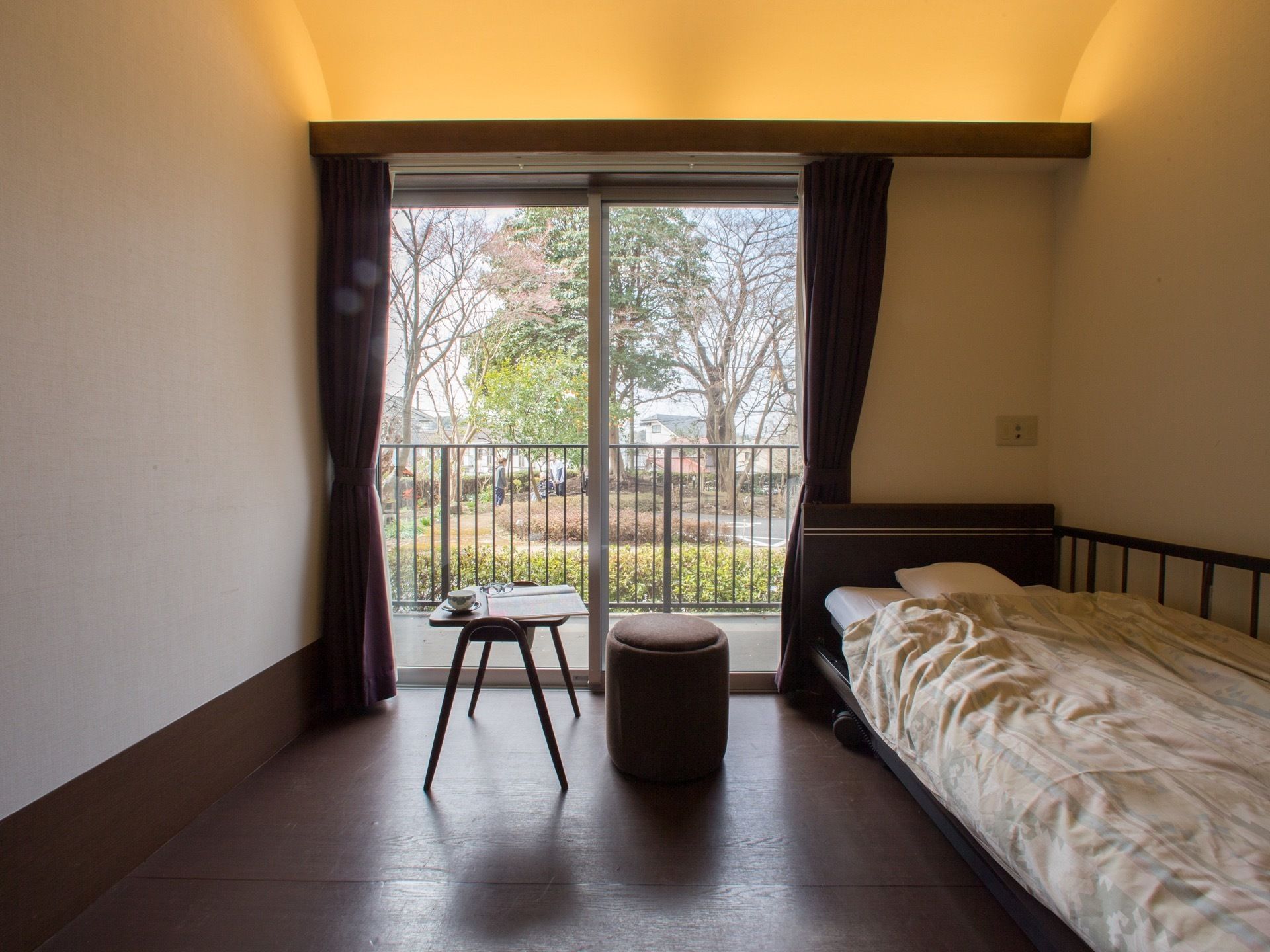 落ち着いた雰囲気のお部屋。窓の外には、広いベランダがある。間接照明が、一際お部屋を素敵に見せてくれる。