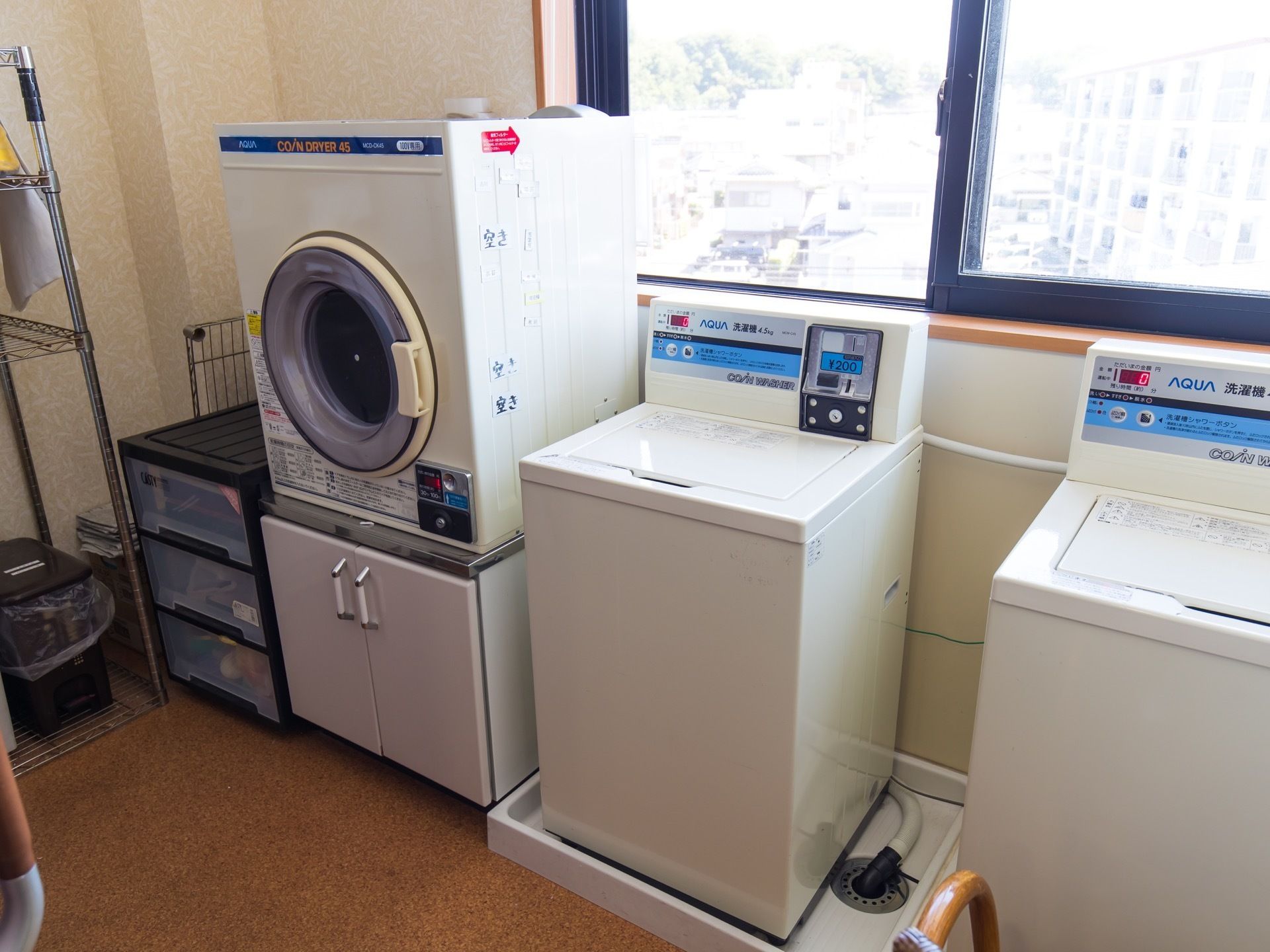 施設内の洗濯室にはコイン式の洗濯機と乾燥機が設置されている。部屋には大きな窓があり、開放感のある空間になっている。