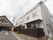 ２階建て構造になっている建物である。白を基調とした壁に、落ち着きのある色合いのベランダが設置され、モダンな印象である。