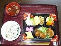 揚げ物や野菜の煮物、サラダや吸い物、ワカメごはんのセット