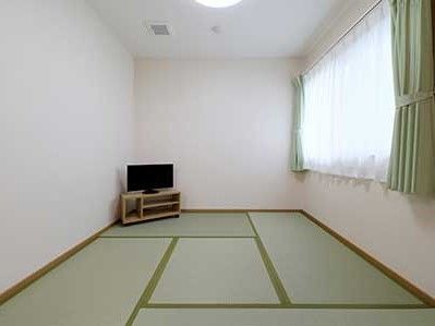 窓から自然光の入テレビの設置された畳の和室