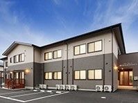 白とグレーのツートーンカラーの2階建ての建物