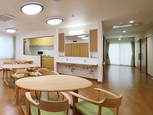 ４名用のテーブルセットがいくつか置かれた食堂では、手洗い場やシステムキッチンがあり開放的な空間となっている。
