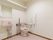 洗面台が設置されている広いトイレである。壁には、アームレストや手すり、呼び出しボタンが設置されている。