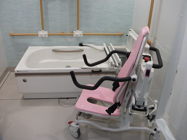 壁に手すりがあり、座ったまま入浴できる設備のある浴室
