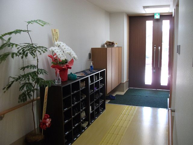 入口のドアから中に入っても段差のない構造になっており、安全である。靴箱があり、花が飾られ、壁には手すりが付いている。