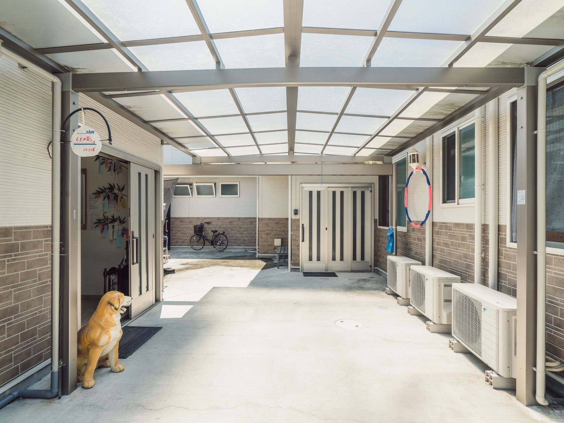 白を基調とした明るく開放感のあるエントランスである。置物の犬が番犬代わりにいる。扉は白い自動ドアである。