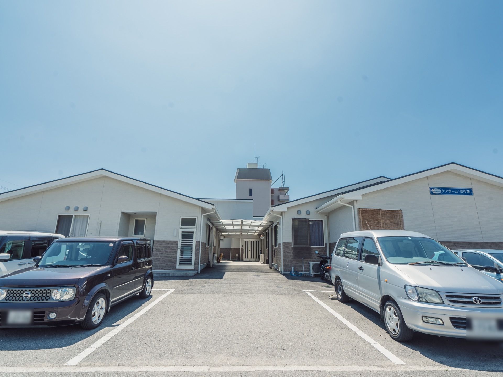 白を基調とした平屋建ての建物が２棟建っている。周辺は駐車スペースになっており、一帯はバリアフリー仕様である。