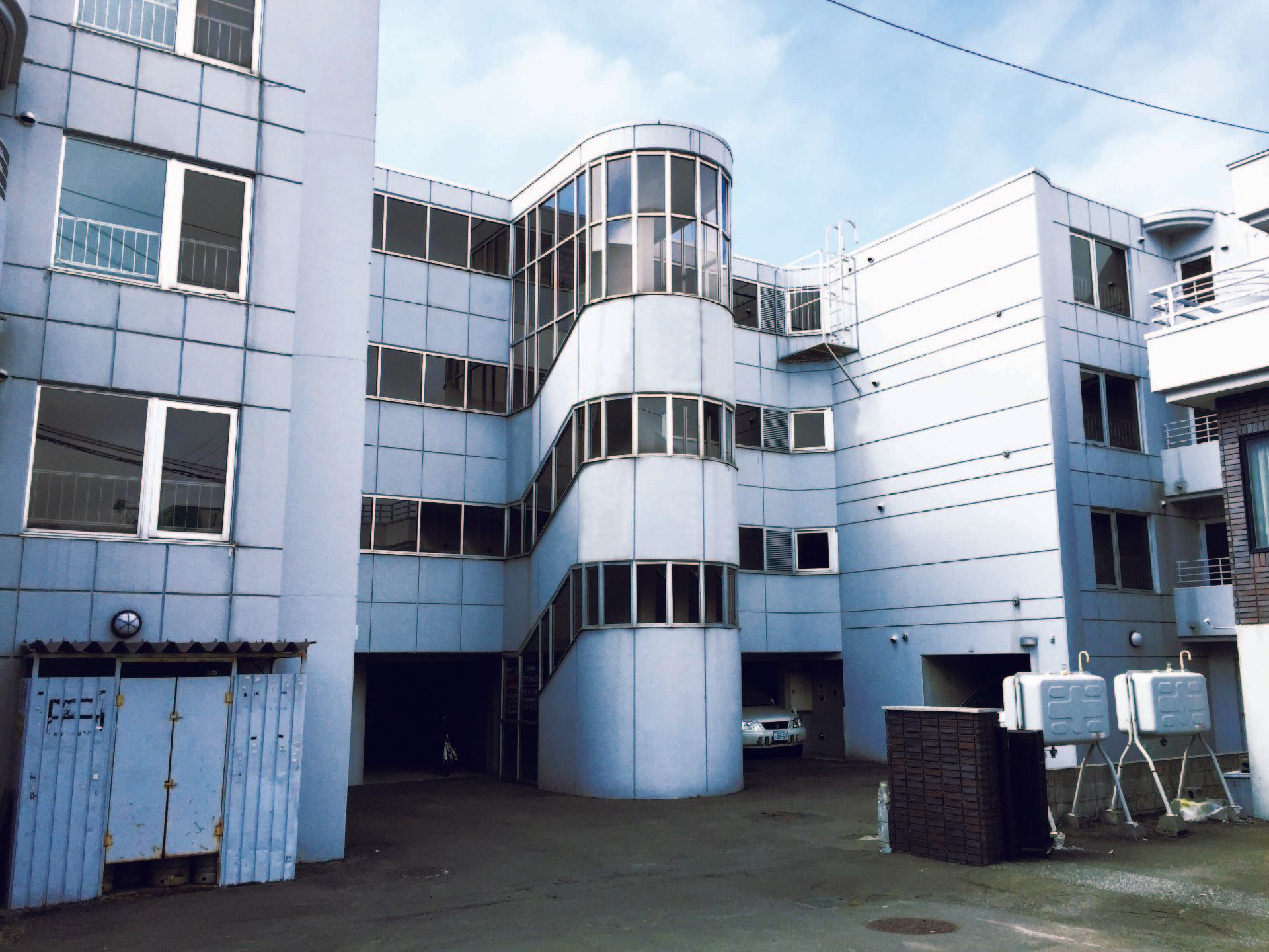 白を基調とした４階建ての建物である。窓の内側に手すりが設けられているものが多くあり、安全対策がとられている。