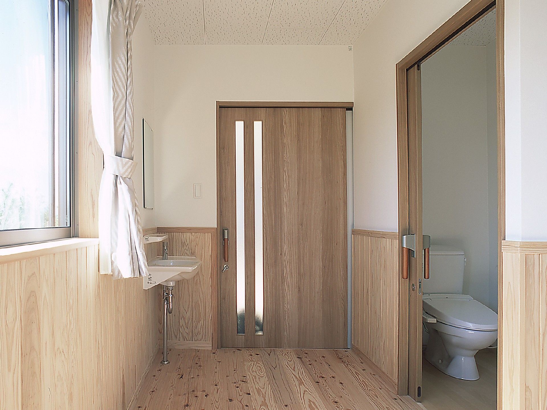 共有のトイレには温水洗浄便座が備わっているので、冬でもお身体を冷やすことがない。外の通路には鏡付きの洗面台が設けられている。