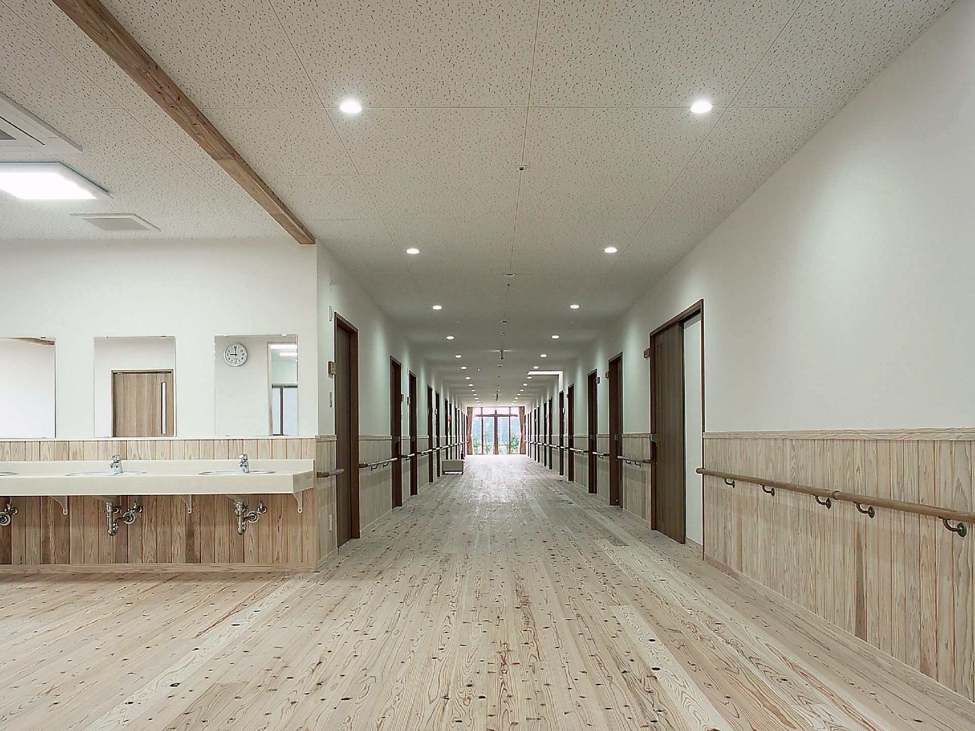 廊下は十分な幅が設けられているので、人がすれ違う際にもストレスなく移動できる。天井には２列に照明が設置されている。