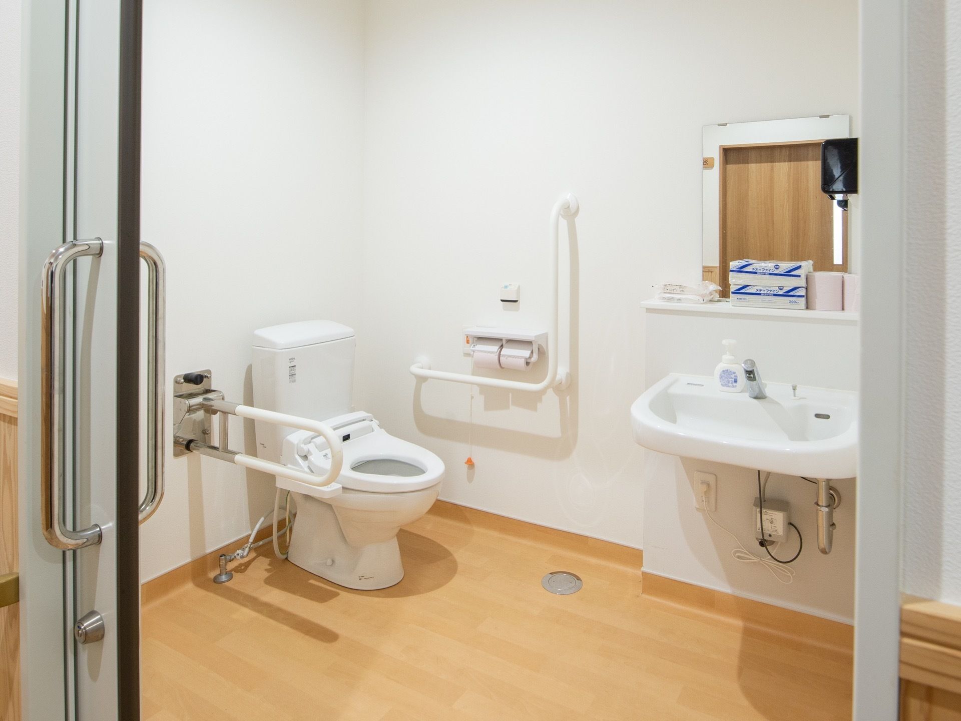 トイレには手すりと呼び出しボタン、洗面台が備えつけられている。扉が引き戸になっているため、出入りがしやすくなっている。