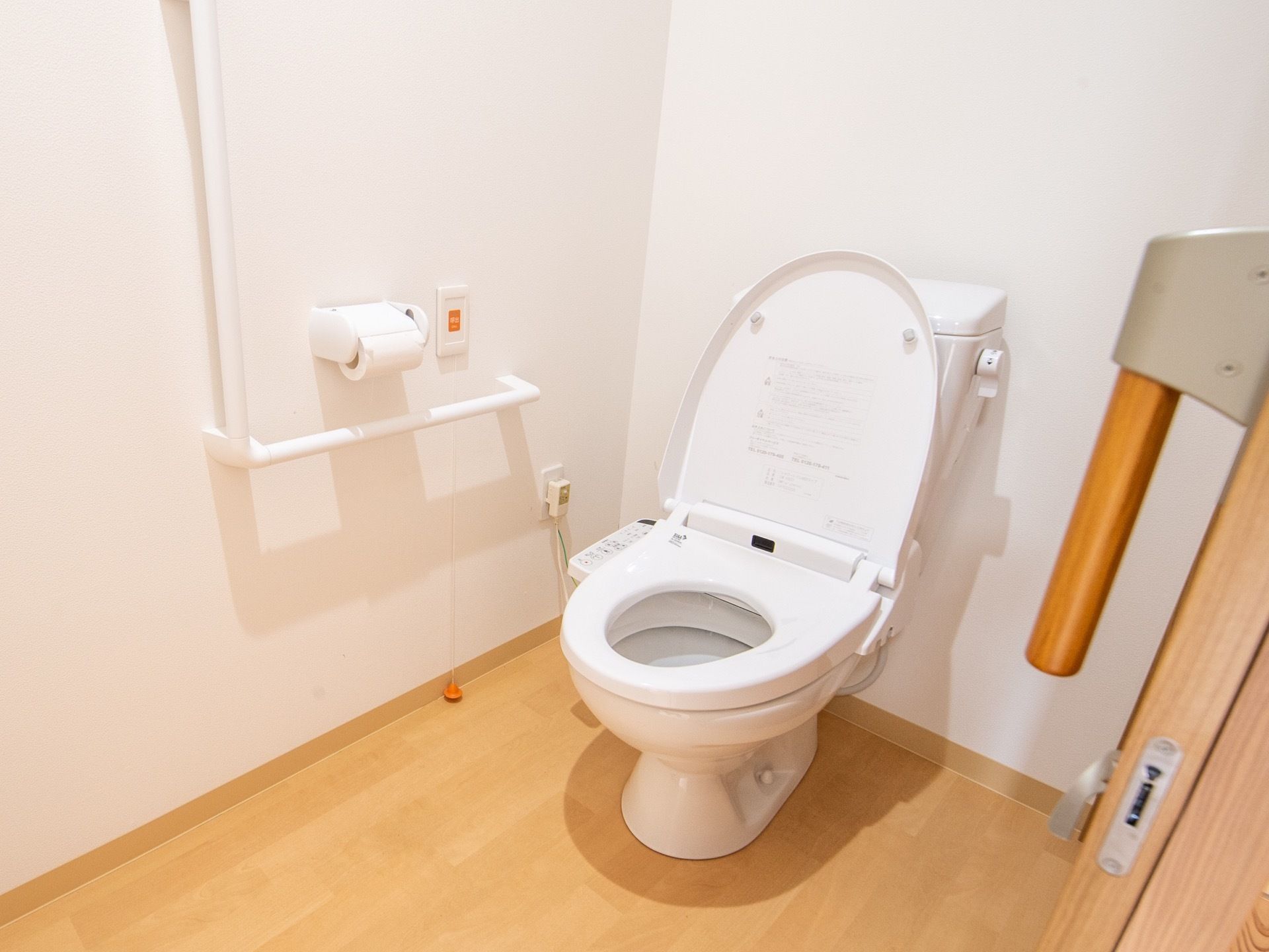 トイレにはＬ字型の手すりと呼び出しボタンが備えつけられている。紐を引っ張ることでも人を呼ぶことができる。
