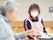 女性スタッフが入居者様の食事をサポートしている様子。世間話などをしながら楽しく食事をすることが可能。