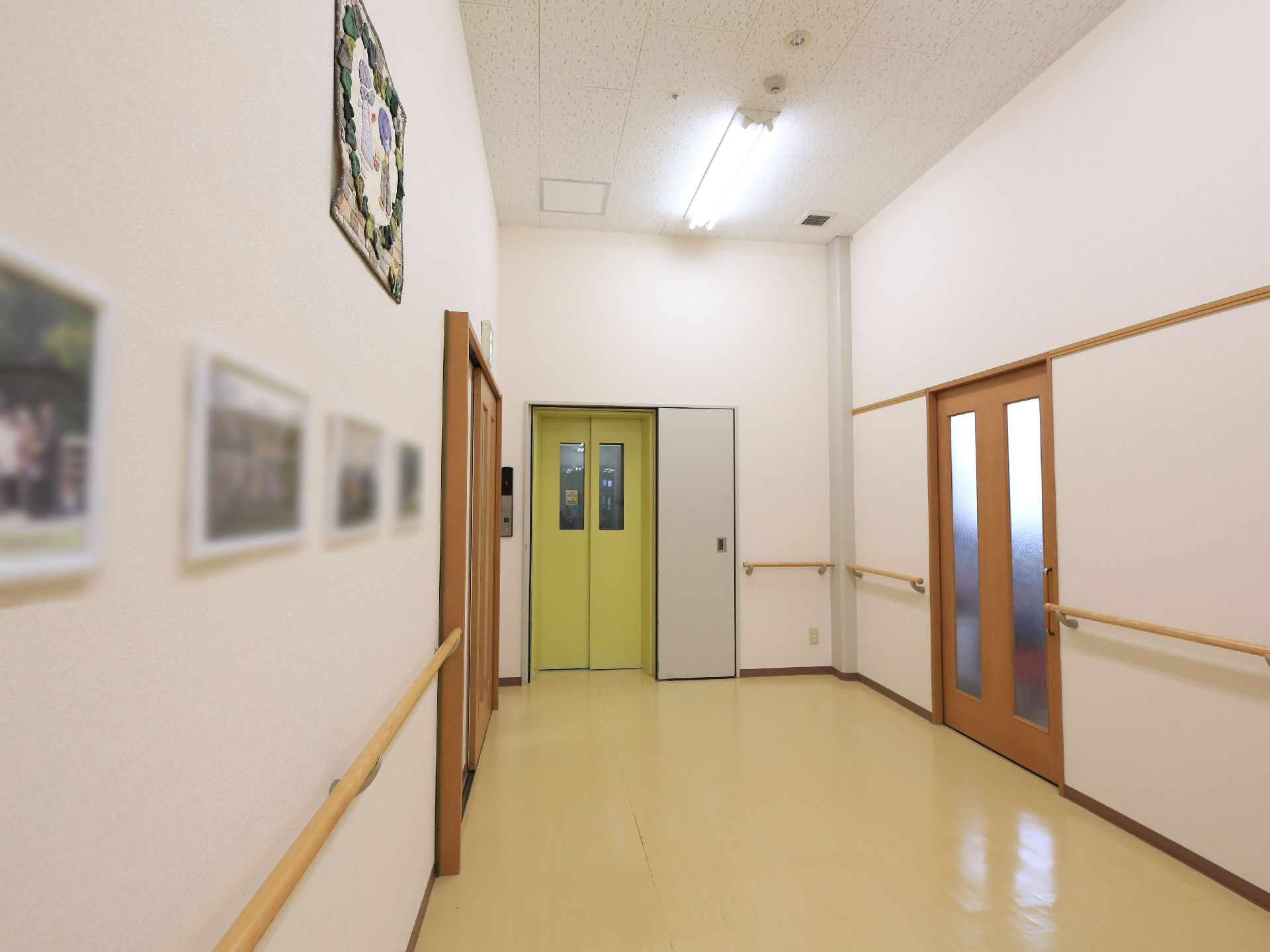 幅が広い廊下になっており、黄緑色の扉のエレベーターが設置されている。手すりを壁全面に設置しており、体を支えながら移動できる。