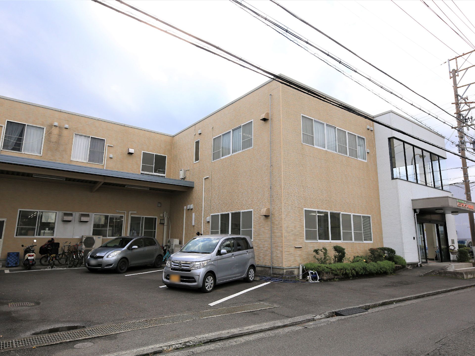 施設はブラウン色の外壁で、３階建ての建物になっている。屋根のついた駐輪場が設置されており、多くの自転車等を停めることができる。