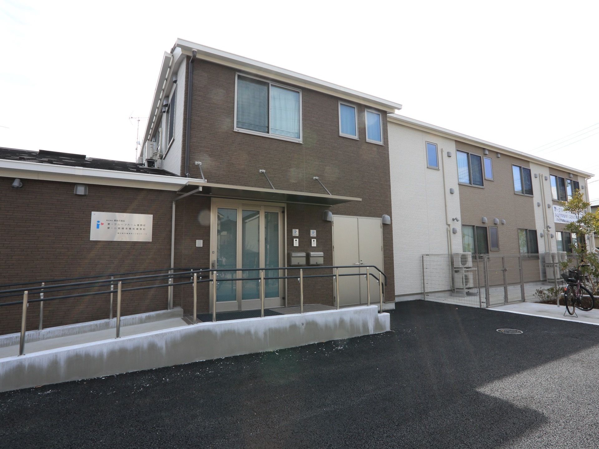 茶色とベージュ系の落ち着いた色合いの建物。玄関まではスロープになっており、車椅子をご利用の方も安全に行き来ができる。